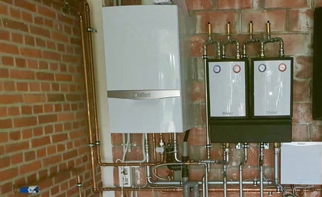 Twee Vaillant-ketels met verdelers tegen een bakstenen muur